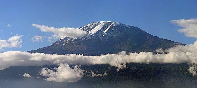 Mount Kilimanjaro, the snow-capped highest peak in Africa, surrounded by beautiful savannah landscapes.