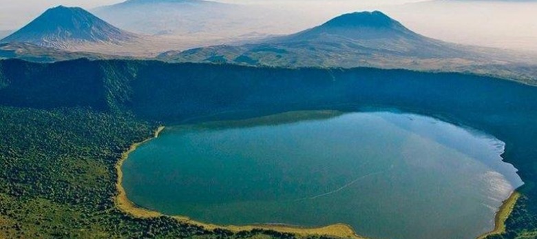 Aerial view of Ngorongoro Crater, Tanzania, showcasing its lush green landscape and diverse wildlife.